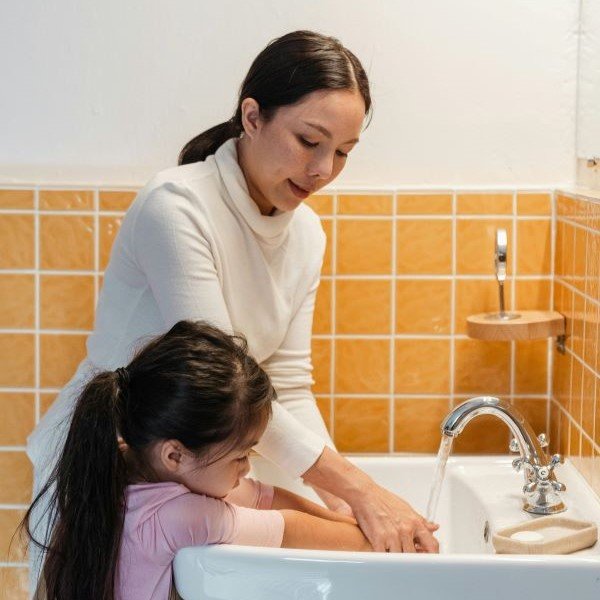 A mother and daughter washing their hands